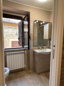 ein Bad mit einem Waschbecken, einem WC und einem Fenster in der Unterkunft Giadahouse in Vico nel Lazio