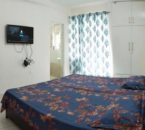 德拉敦2 Bed Room Independent Apartment in Dehradun的一间卧室配有一张带蓝色毯子的床和窗户。