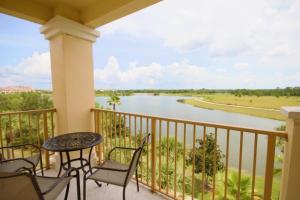 balcón con mesa, sillas y río en Penthouse Lake View 3 bed Condo Convention Center condo, en Orlando