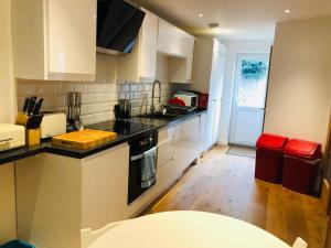 a kitchen with white cabinets and a black counter top at Beach Road in Carlyon Bay