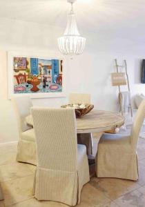 una sala da pranzo con tavolo, sedie e lampadario pendente di Your Happy Place ON THE BEACH! a Key Colony Beach