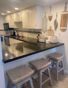 a kitchen with a counter and two stools in it at Your Happy Place ON THE BEACH! in Key Colony Beach