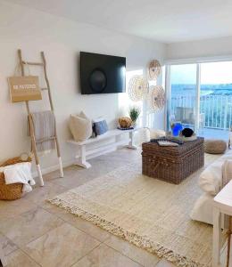 a living room with a couch and a tv on the wall at Your Happy Place ON THE BEACH! in Key Colony Beach