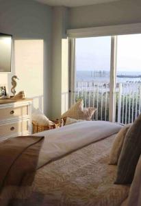 a bedroom with a bed with a view of the ocean at Your Happy Place ON THE BEACH! in Key Colony Beach