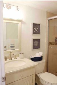 Baño blanco con lavabo y aseo en Your Happy Place ON THE BEACH!, en Key Colony Beach