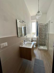 La salle de bains est pourvue d'un lavabo, d'une douche et d'un miroir. dans l'établissement Casa Graziella, à Cecina