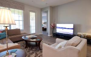 ein Wohnzimmer mit einem Sofa und einem TV in der Unterkunft Vista Cay Luxury Retreat condo in Orlando