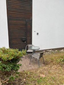 2 chaises et une table en face d'un bâtiment dans l'établissement Ferienwohnung auf dem Betzenberg, à Kaiserslautern