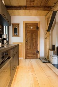 a kitchen with a wooden floor and a wooden door at Kulturdenkmal Umgebinde1657 in Bad Schandau