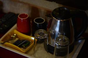 a tray with a coffee pot and glasses on it at Hotel Fifu in Jaisalmer