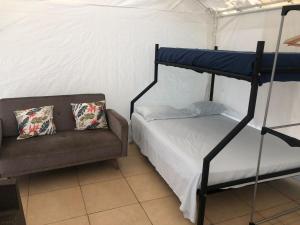 San Rafael的住宿－Glamping Rio Celeste Heliconia，一间卧室配有双层床和沙发