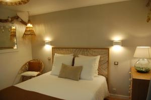 Schlafzimmer mit einem Bett mit weißer Bettwäsche und Kissen in der Unterkunft L'Abri du Marin in Audierne