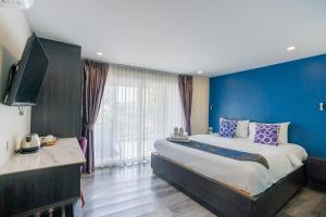 um quarto com uma cama grande e uma parede azul em Anchan Hotel & Spa em Hua Hin