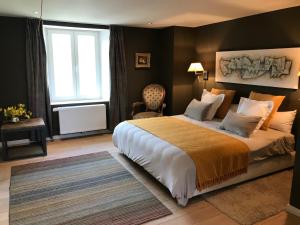 een slaapkamer met een groot bed en een raam bij La Maison Blanche de Martué in Florenville
