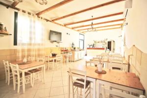 a dining room with tables and chairs and a tv at Agriturismo Antares in San Foca