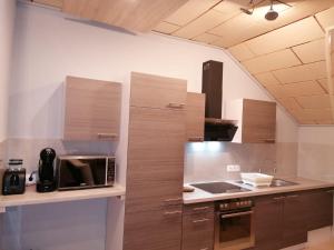 a kitchen with wooden cabinets and a counter top at Apartment-Design in Altenstadt