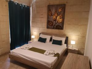 um quarto com uma cama grande e 2 mesas de cabeceira em Two gate town house em Senglea