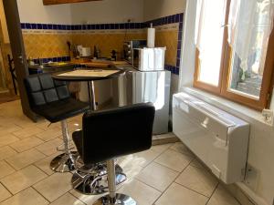 cocina con mesa y 2 taburetes en La Dolce Vita climatisation animal interdit en Bargemon