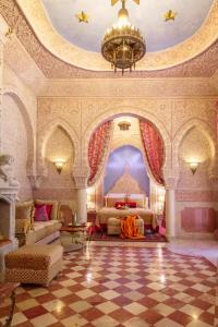 ein großes Schlafzimmer mit einem Bett und einem Kronleuchter in der Unterkunft Riad Dar El Malaika in El Jadida