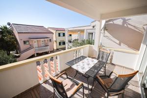 d'un balcon avec une table et des chaises. dans l'établissement Apartments by the sea Petrcane, Zadar - 3285, à Petrčane