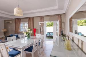 comedor con mesa blanca y sillas en villa Pergola en Hammamet