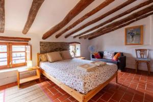 sypialnia z łóżkiem i kanapą w obiekcie Cal Joanet, acollidora caseta a Gratallops w mieście Gratallops