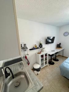 a kitchen with a sink and a desk in a room at Les Logis de Paray Appartement 201 in Paray-le-Monial