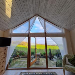 a large window in a living room with a view at The Old Pottery, Unique Views & Spa-like Bathroom in Ashburton