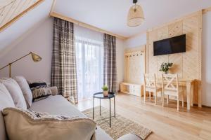ein Wohnzimmer mit einem Sofa und einem Tisch in der Unterkunft Olczańska Kotlina Apart&Room in Zakopane