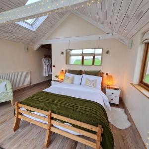 a bedroom with a large bed and a skylight at The Old Pottery, Unique Views & Spa-like Bathroom in Ashburton
