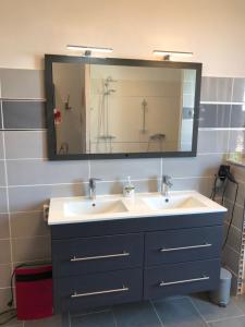 a bathroom with two sinks and a large mirror at Maison au calme au coeur de village in Saint-Georges-dʼOrques