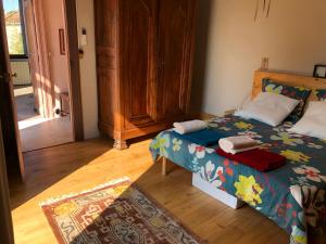 a bedroom with a bed and a wooden floor at Maison au calme au coeur de village in Saint-Georges-dʼOrques