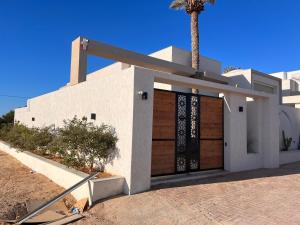 a white house with a palm tree in front of it at Villa Dar lynoute in Taguermess