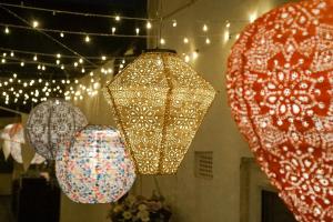 three paper lanterns hanging from a ceiling with lights at Tintern Apartment - Clapham in London