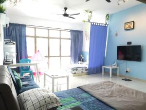 a living room with blue walls and a couch and a tv at Palazio AegeanSea Homestay By Easyhomestay in Johor Bahru
