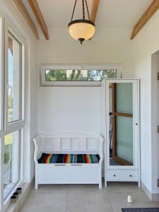 biała ławka w pokoju z oknem w obiekcie Komfortowy domek z kominkiem w mieście Barwice