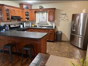 a kitchen with wooden cabinets and a stainless steel refrigerator at Cozy home in El Paso