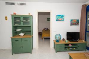 una sala de estar con un armario verde y una mesa en Appartement équipé CALPE Espagne, 4 couchages, terrasse, piscines, climatisation, garage et WIFI gratuits, en Calpe