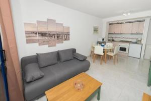 ein Wohnzimmer mit einem Sofa und einem Tisch in der Unterkunft Appartement équipé CALPE Espagne, 4 couchages, terrasse, piscines, climatisation, garage et WIFI gratuits in Calpe