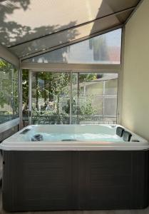 a large tub in a room with a large window at Maison avec Jacuzzi Marseille in Marseille