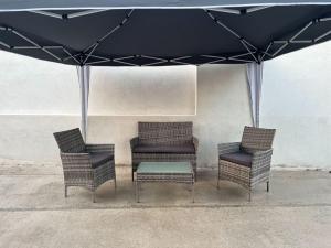 a group of chairs and a table under an umbrella at Maison avec Jacuzzi Marseille in Marseille
