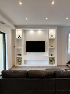 a living room with a couch and a flat screen tv at Maison avec Jacuzzi Marseille in Marseille