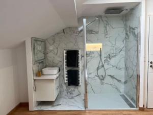 W łazience z marmurową ścianą znajduje się prysznic. w obiekcie Maison avec Jacuzzi Marseille w Marsylii