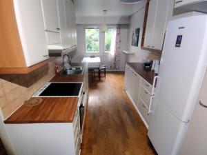 eine Küche mit weißen Schränken und einem weißen Kühlschrank in der Unterkunft 2 bedrooms house with garden in Rauma