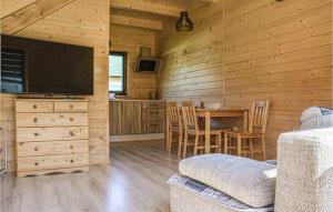 una sala de estar con mesa y TV en una cabina en Cozy Home In Grzybowo With Kitchen, en Grzybowo