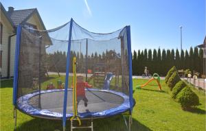 a child playing on a trampoline in a park at Cozy Home In Grzybowo With Kitchen in Grzybowo +9 photos