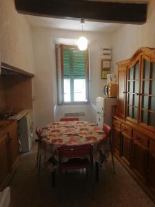 a kitchen with a table with chairs and a window at Duplex meublé Mercantour in Fontan