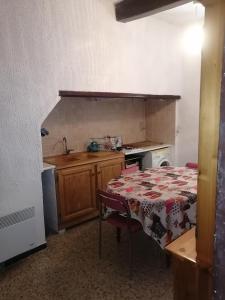 a small kitchen with a table and a sink at Duplex meublé Mercantour in Fontan +16 photos