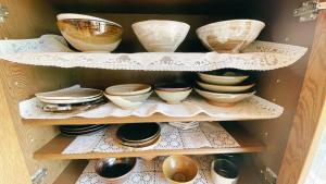 a wooden shelf with bowls and plates on it at AKARIYA Home&Hostel in Karatsu