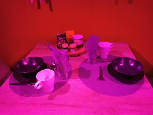 Côté spa : طاولة عليها أضواء أرجوانية وأوعية وأكواب